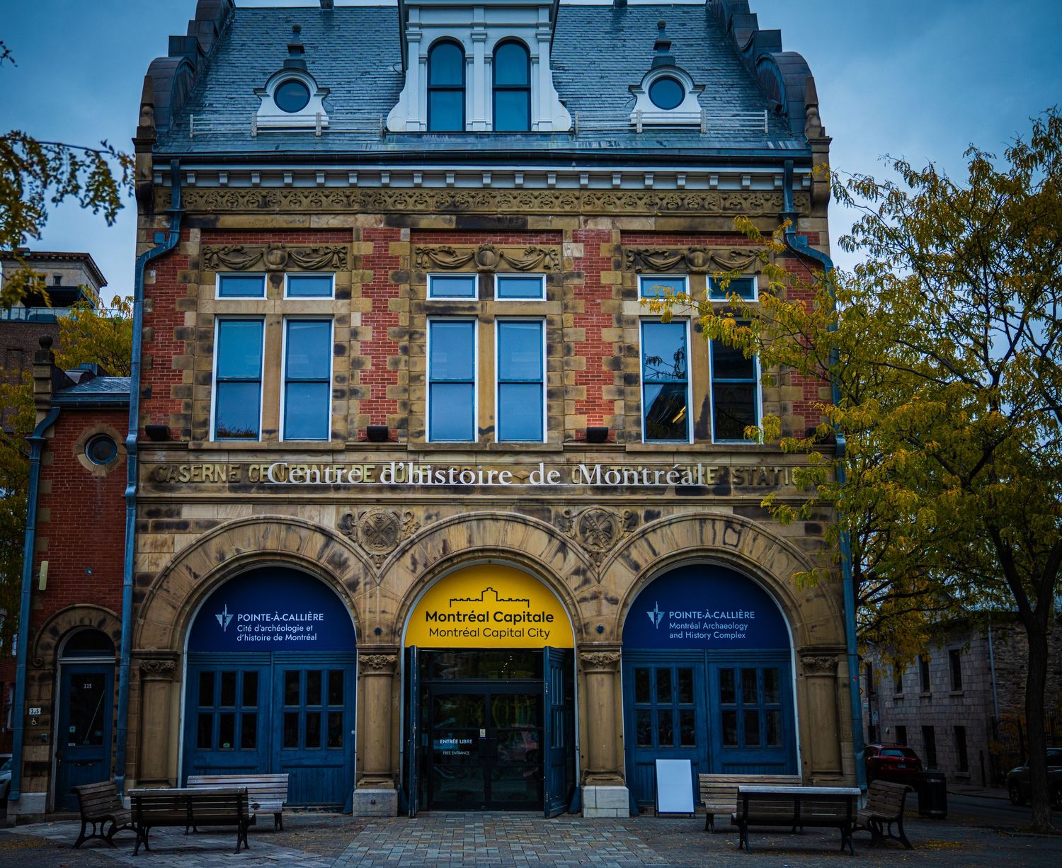 Historic stone building with arched windows and ornate architectural details under blue sky.