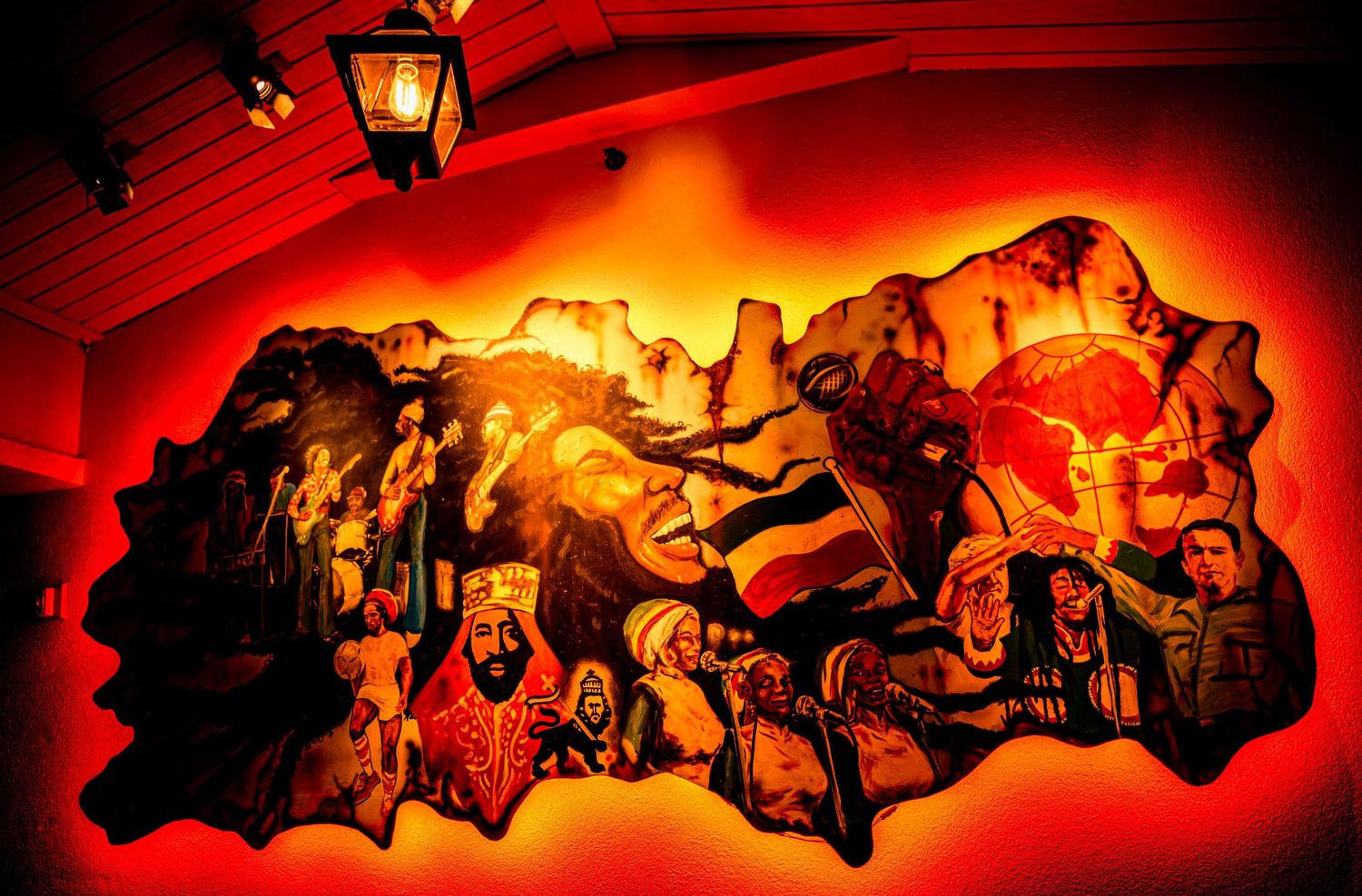 Row of orange-lit decorative wall sculptures creating an atmospheric glow against a dark background.