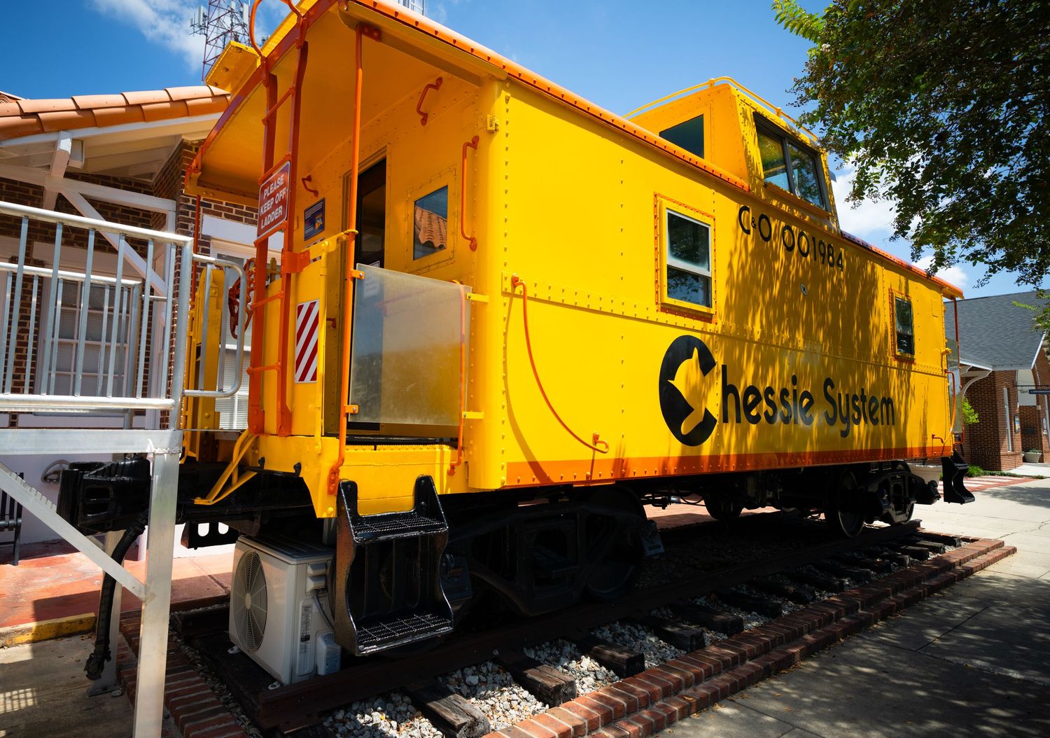 Bright yellow vintage train cars displayed outdoors at a railway museum.