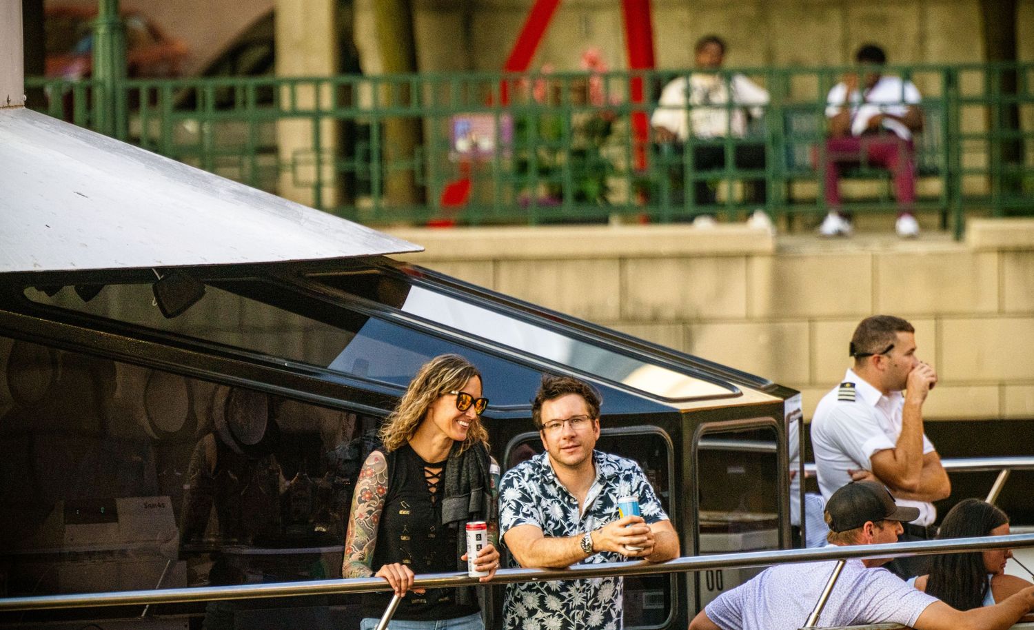 People socializing on a waterfront patio during a sunny afternoon.