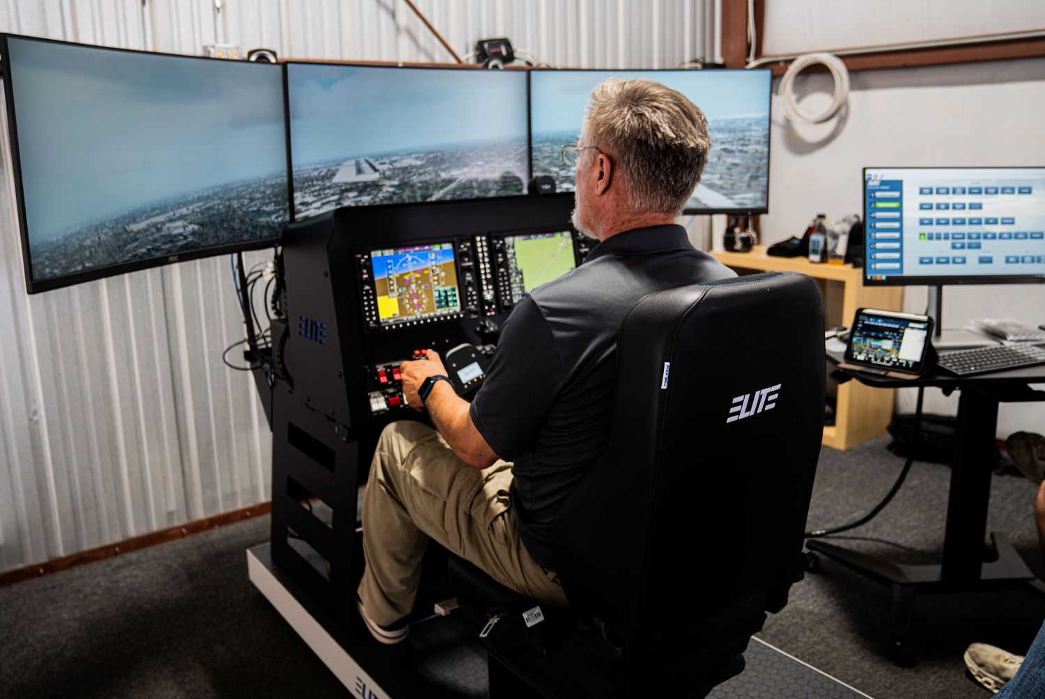 Flight simulator training facility with multiple screens and control stations in a modern classroom setting.