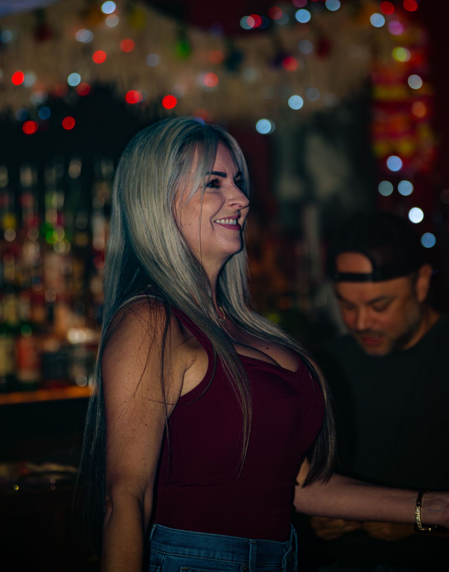Bar patrons enjoying drinks under warm ambient lighting.