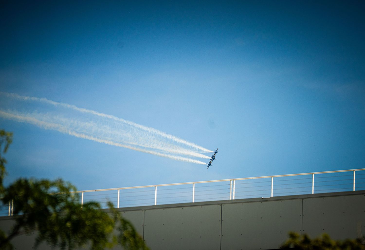 Military aircraft performing aerial maneuvers with white vapor trails in formation.