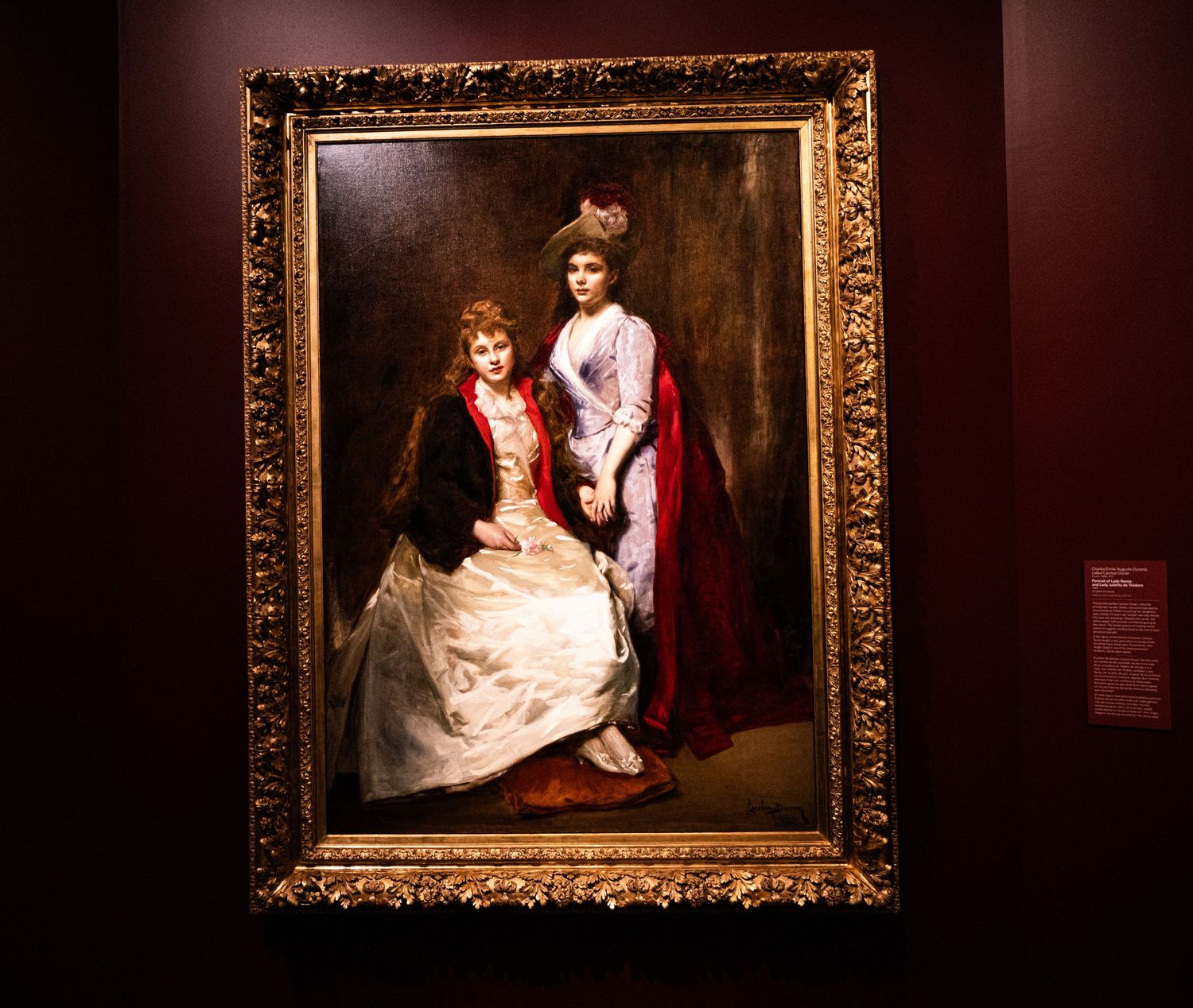 A series of ornate gold-framed classical paintings displayed in a dimly lit museum gallery.