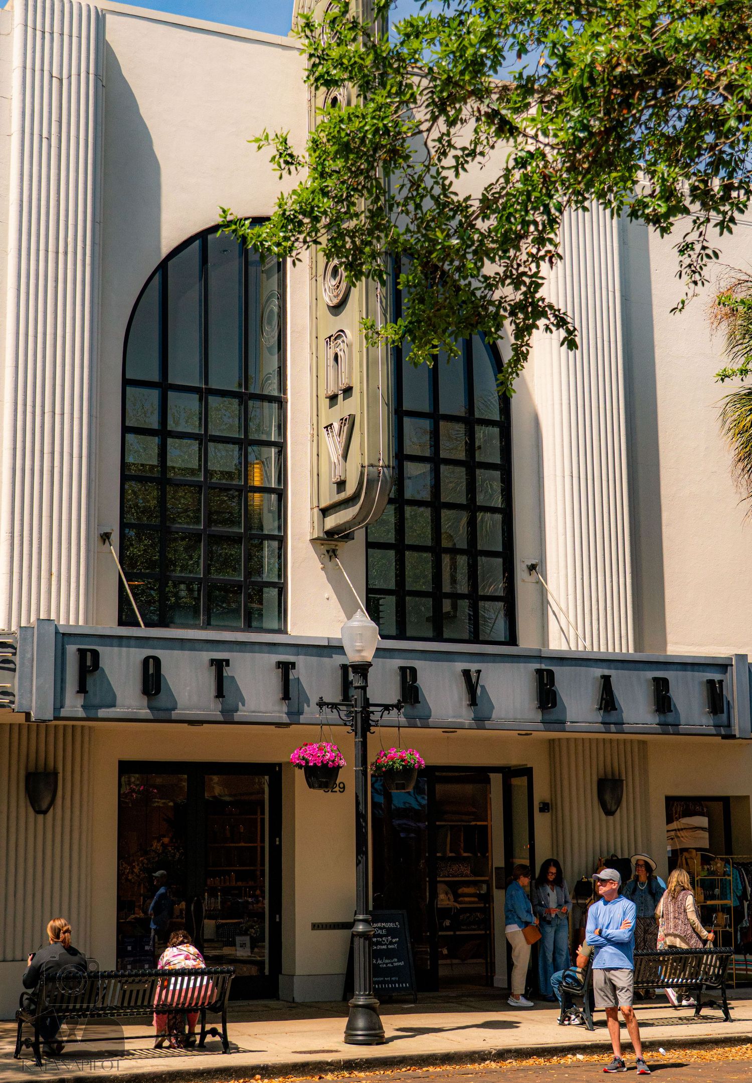 Classical building facade with white columns and arched windows in a shopping area.