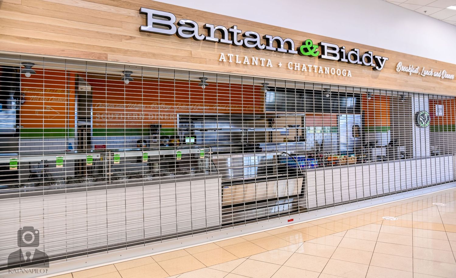 Bann Thai restaurant storefront with green accents and security gate in mall setting.