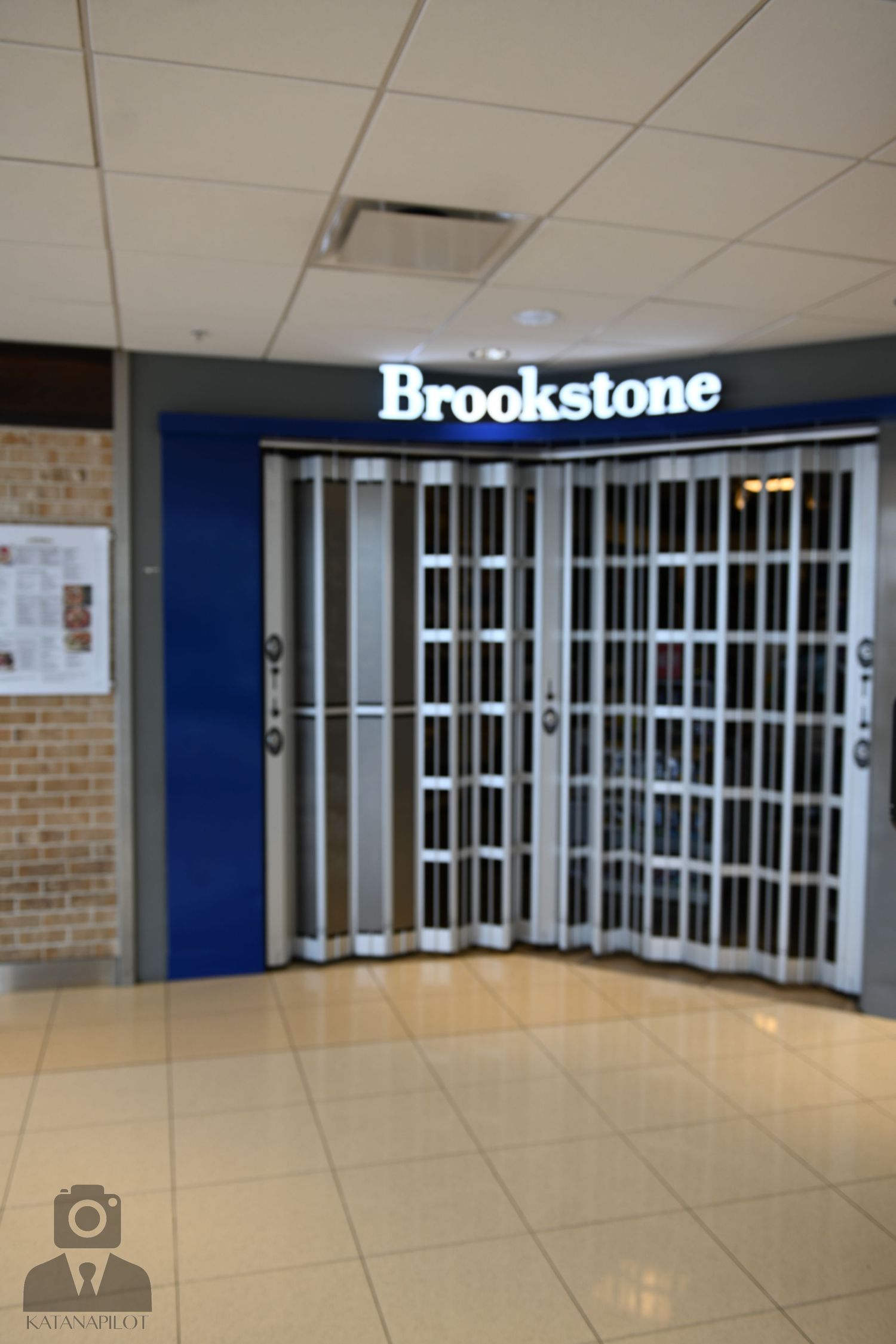 Interior mall corridor showing Brookstone storefront with security gates and tiled flooring.
