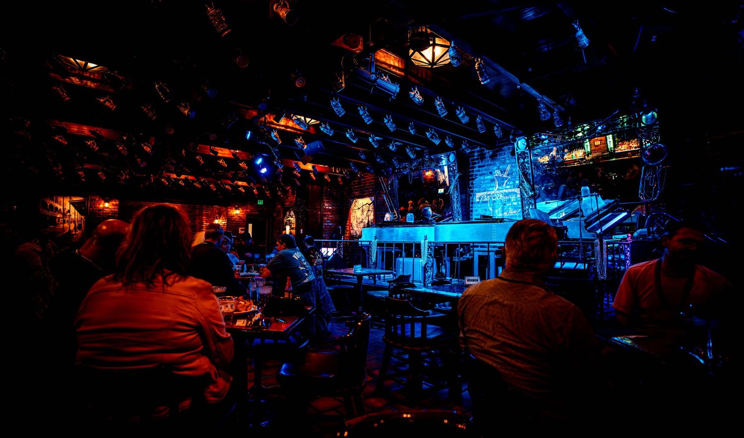 Nighttime scene of illuminated outdoor entertainment area with blue and red lighting creating a moody atmosphere.