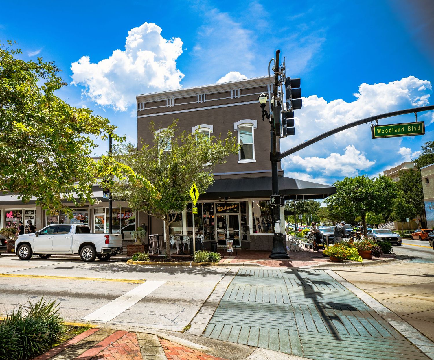 Urban street view showing brick sidewalks and commercial buildings with decorative landscaping.
