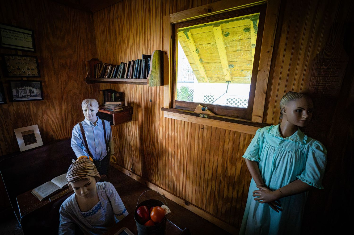 Interior of a historic wooden building with wall-mounted photographs and displays.