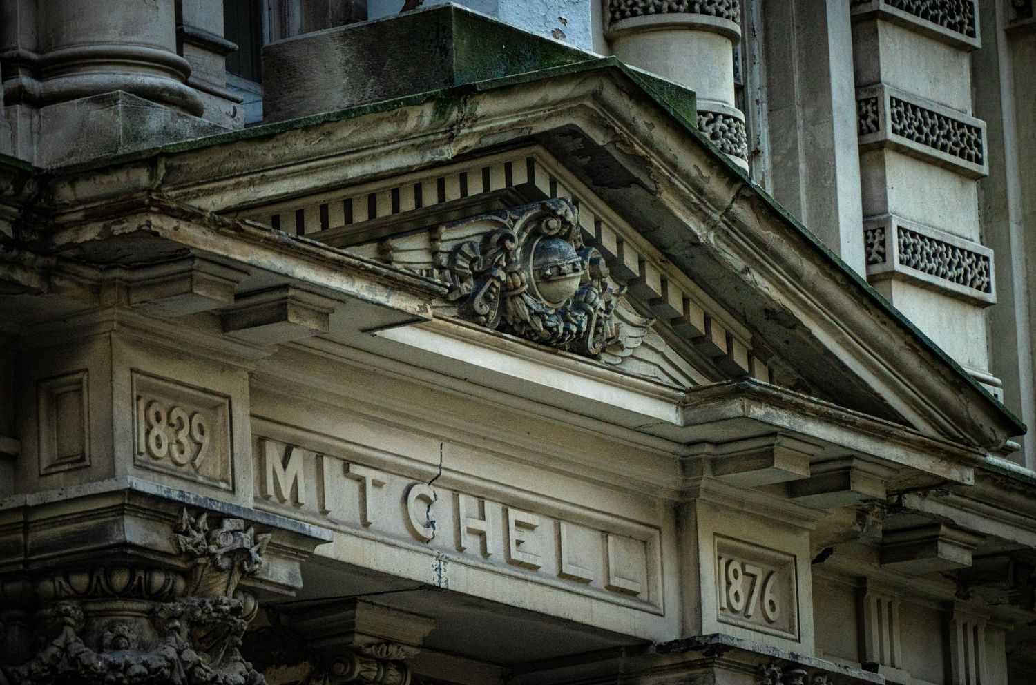 Classical building facade with Mitchell name inscription and ornate architectural details.