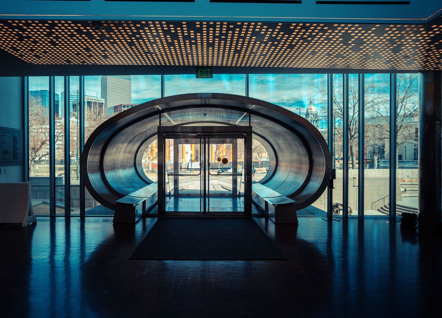 Modern architectural interior with panoramic windows and curved ceiling elements creating a dramatic silhouette.
