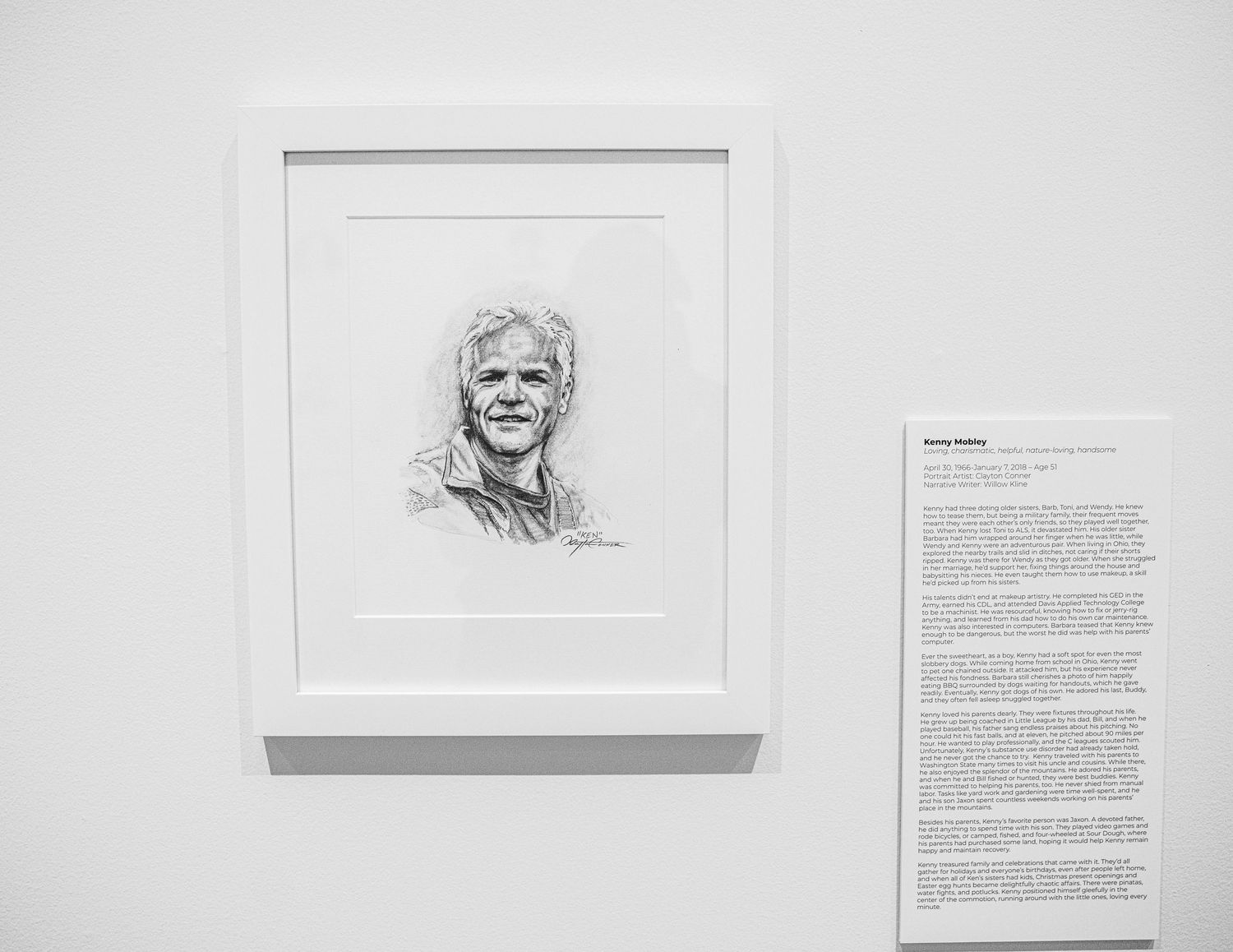 Museum wall featuring framed portrait sketches and descriptive text panels in white gallery space.