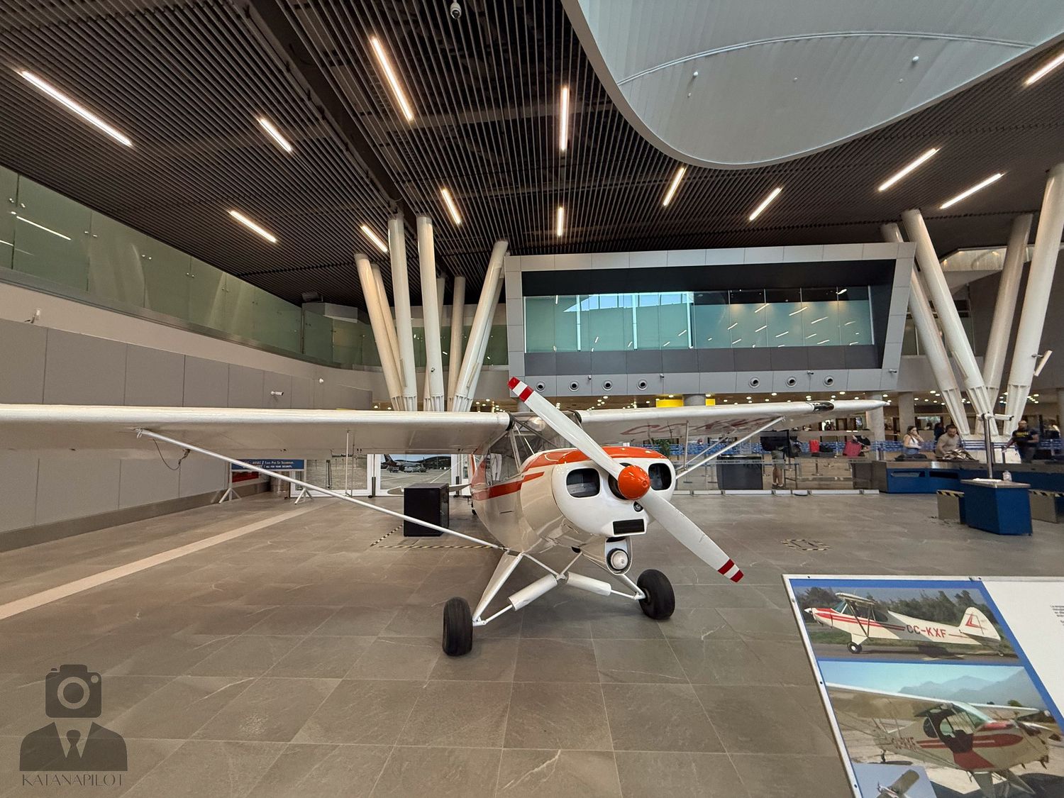 Modern airport hangar interior with small aircraft and bright lighting.