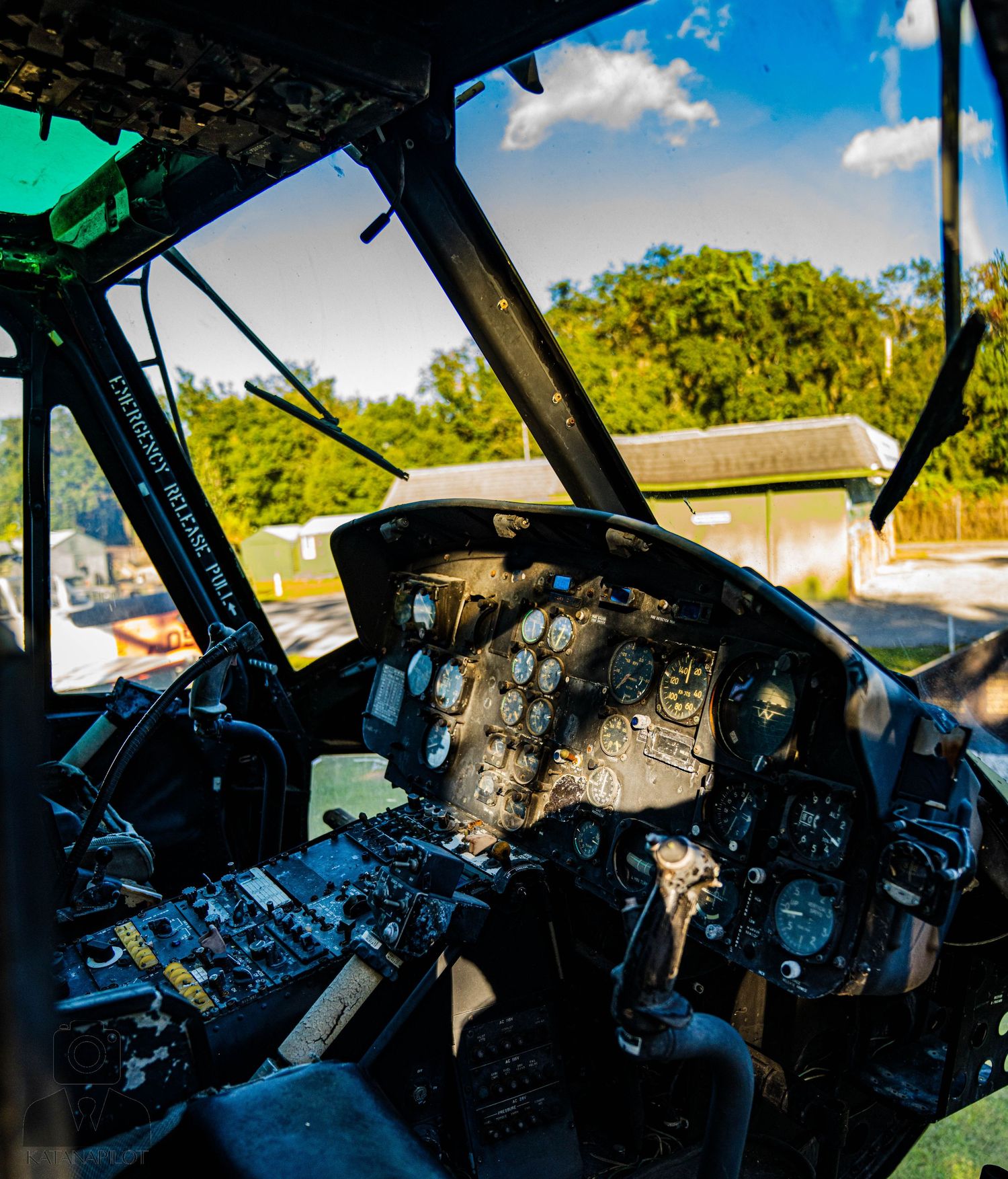 Interior view of damaged aircraft cockpit with broken glass and controls visible.