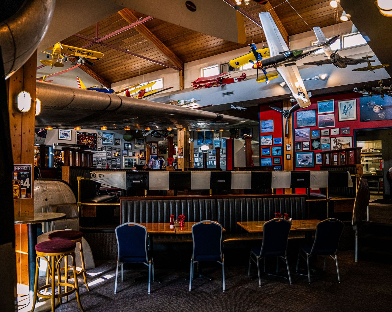 Panoramic view of a rustic bar interior with wooden decor, bar stools, and ambient lighting creating a cozy atmosphere.