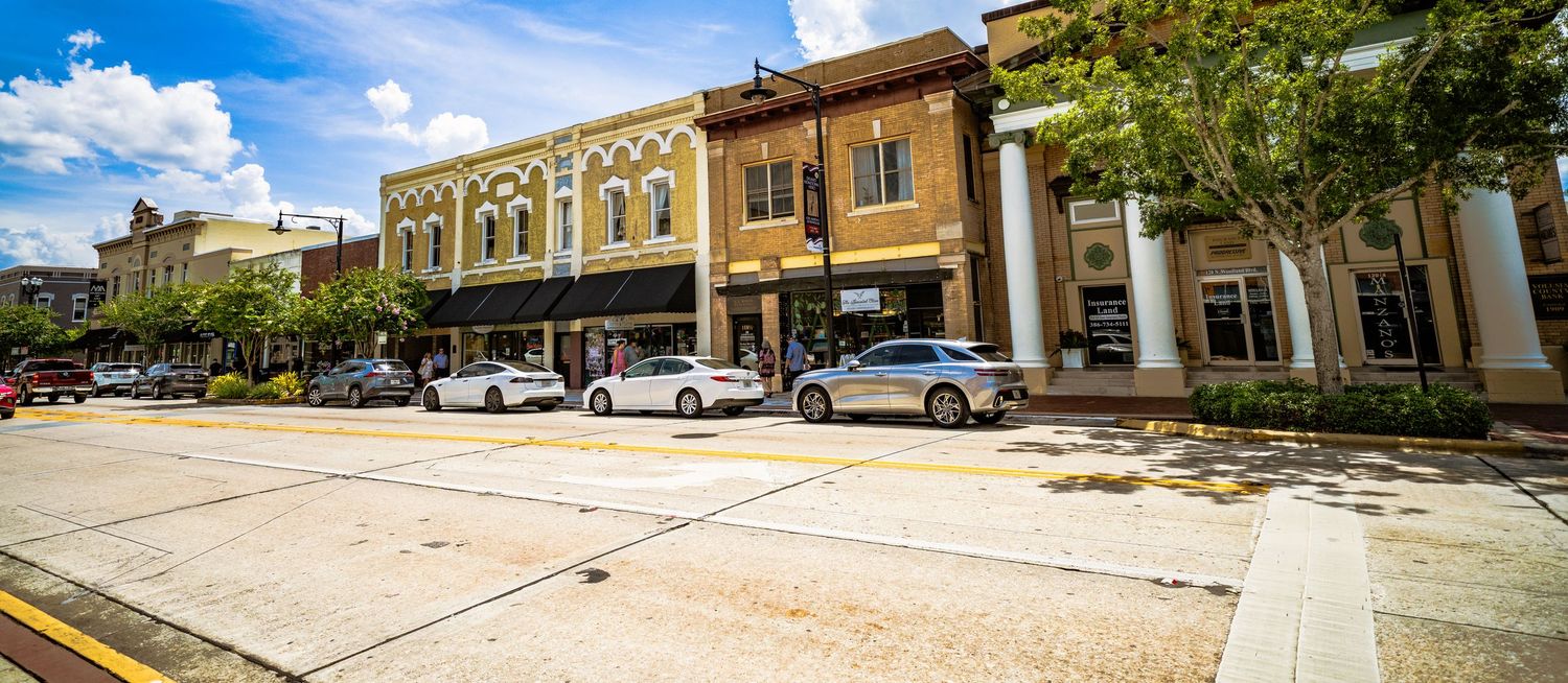 Wide panoramic view of historic downtown Sanford buildings and storefronts under blue sky.
