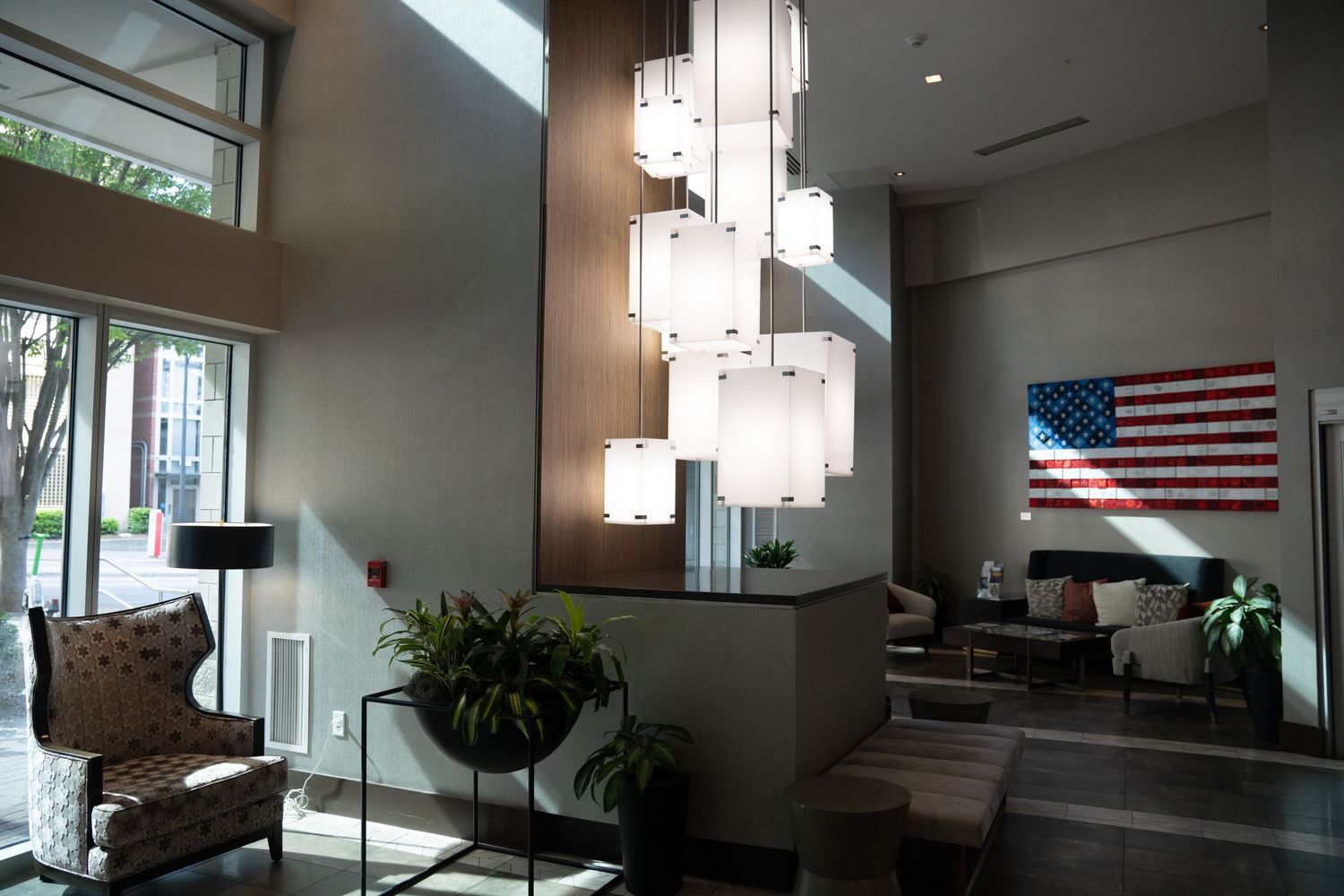 Modern interior hallway with American flag and natural lighting from windows.