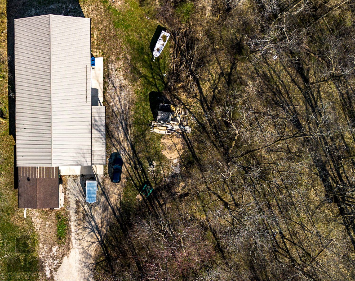 Aerial view of white building structure surrounded by bare trees.