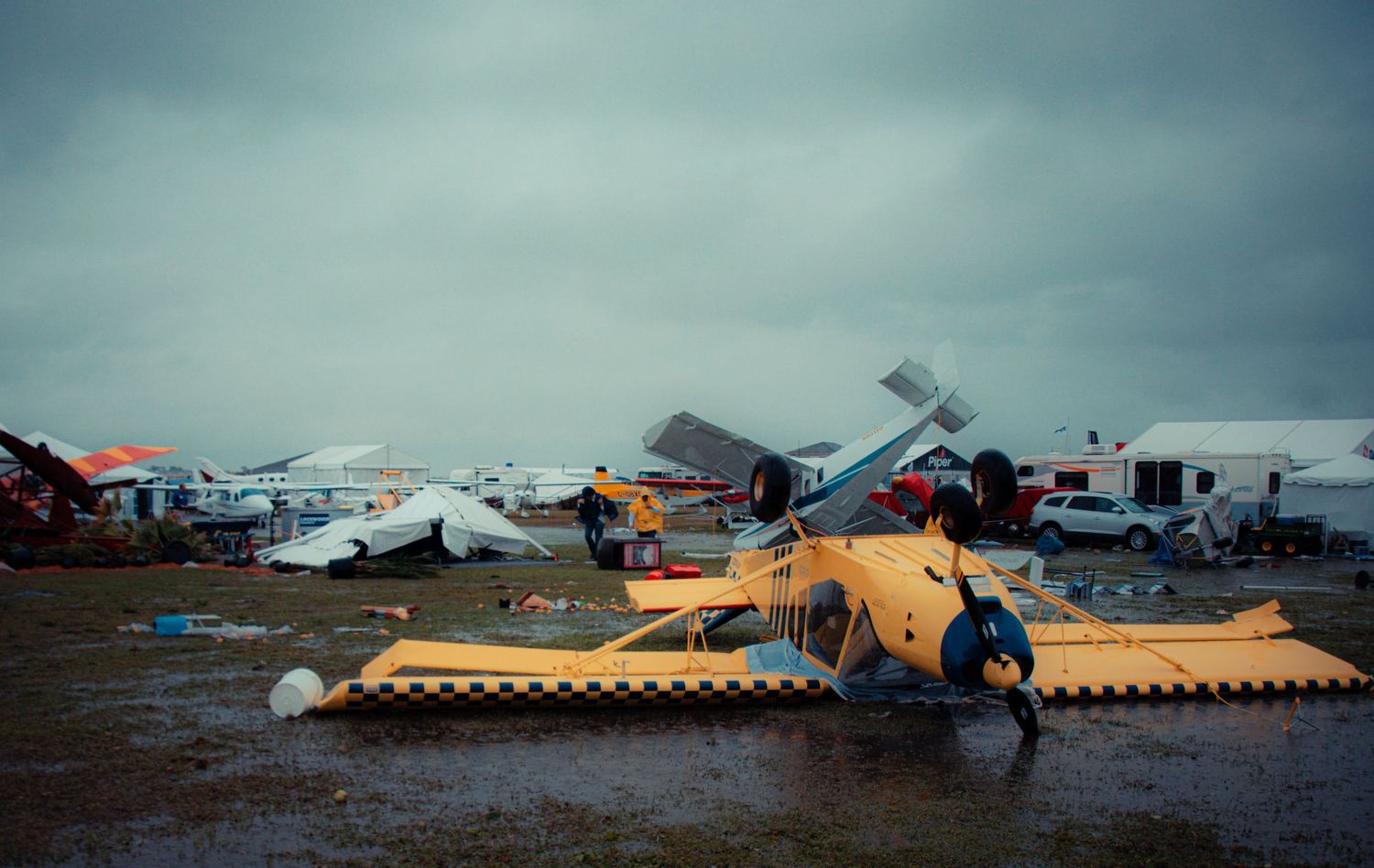 Aerial view of destroyed aircraft and hangars at an airport showing extensive storm or disaster damage.