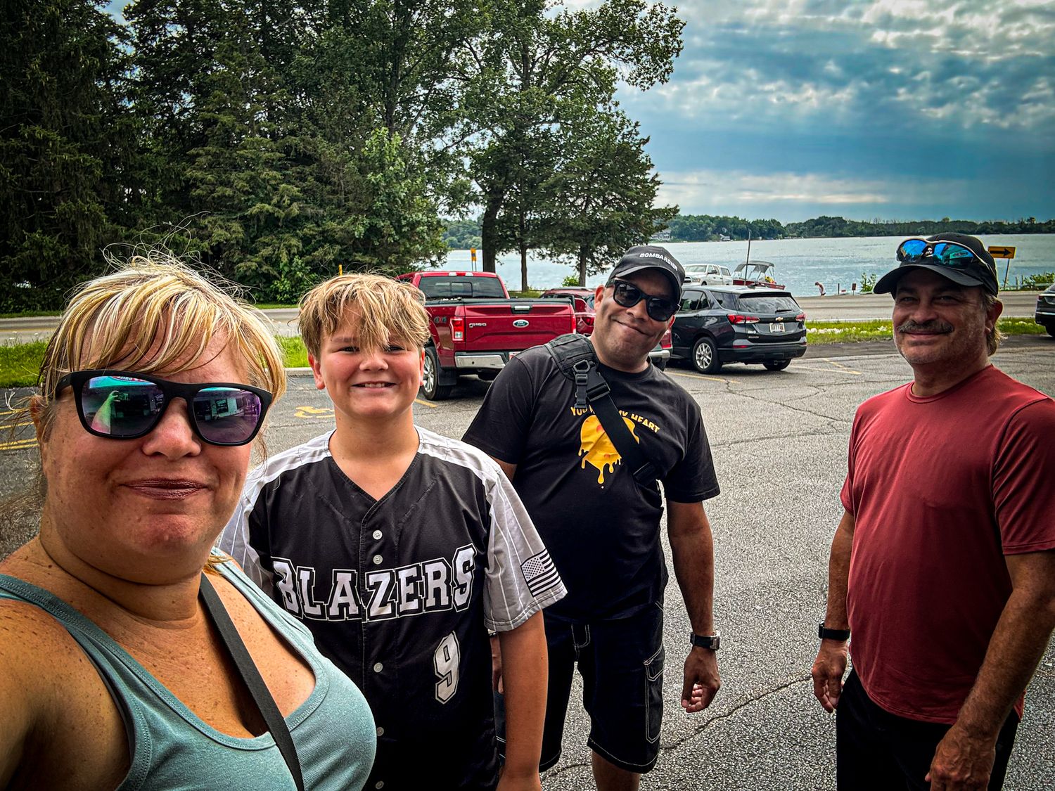 Group enjoying a sunny day by the waterfront with boats visible in the background.