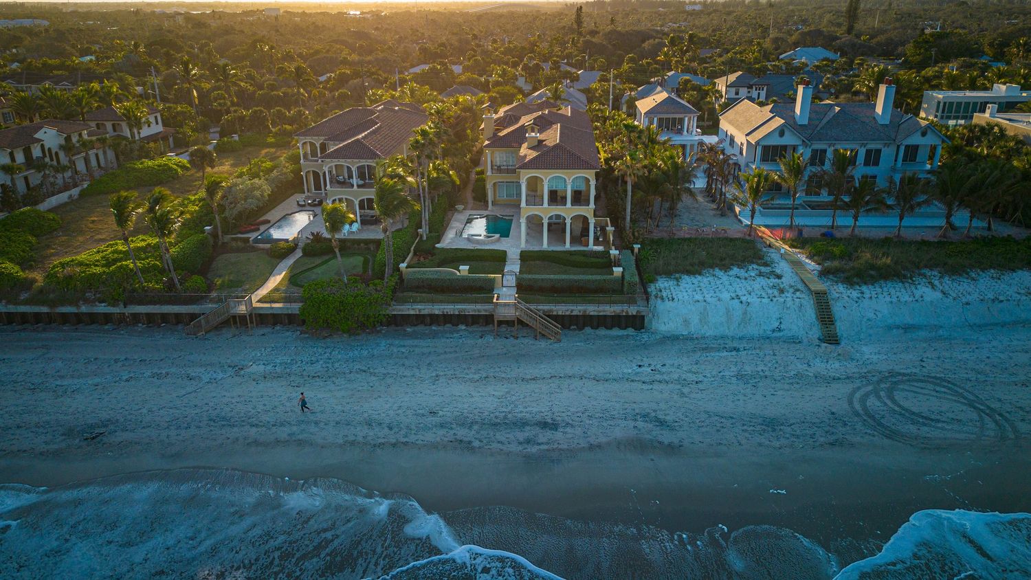 Sunset aerial panorama of coastal homes and waterfront properties.