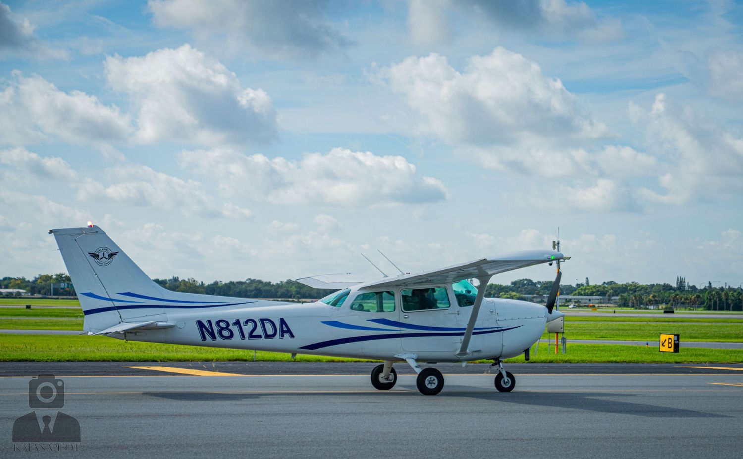 A white Cessna aircraft with registration N8129A parked on a sunny airfield tarmac.