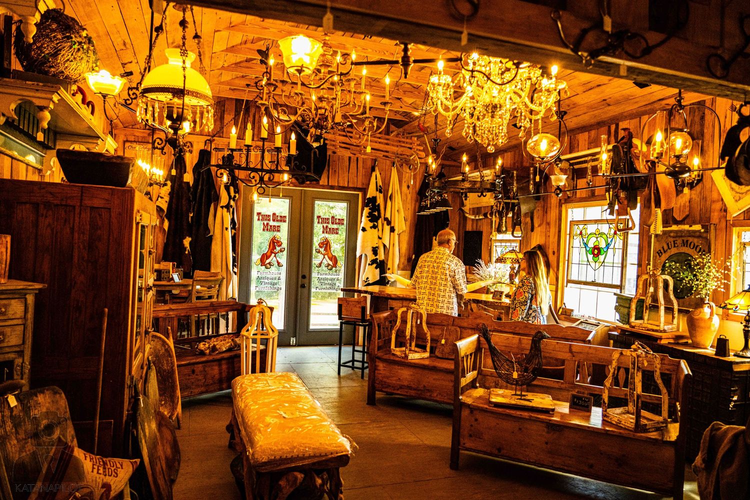 Long corridor of an antique store illuminated by warm lighting and filled with vintage treasures.