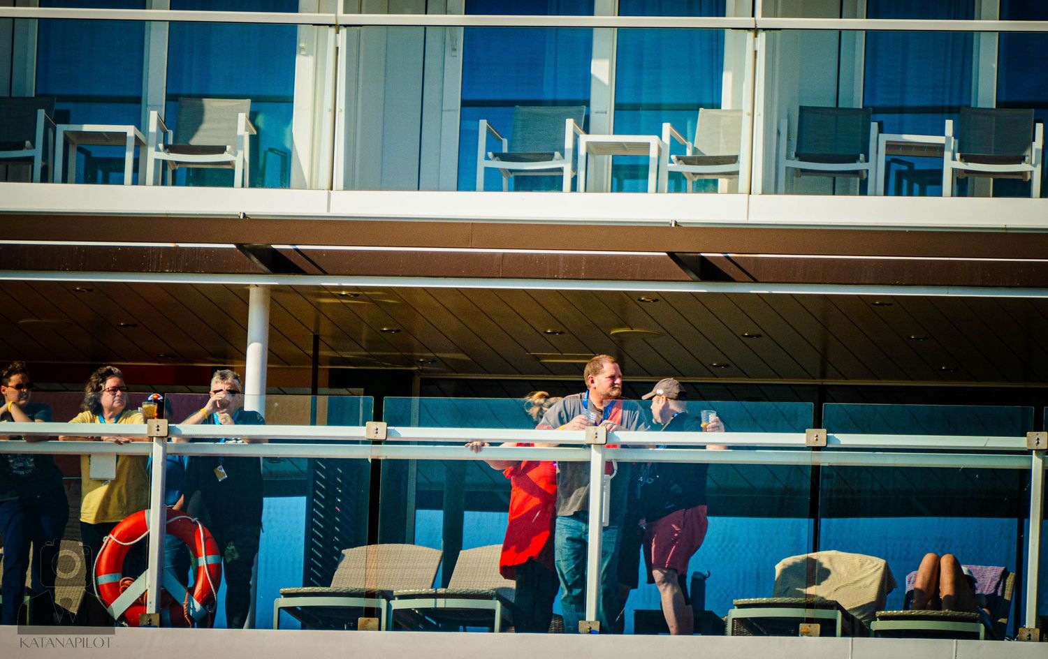 Spectators watch from multiple levels of stadium seating as athletes compete on a sports field below.