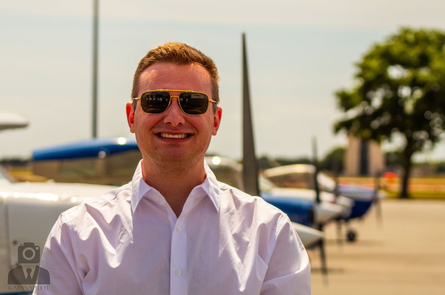 Aviation team members in matching white shirts gather outside near parked aircraft.