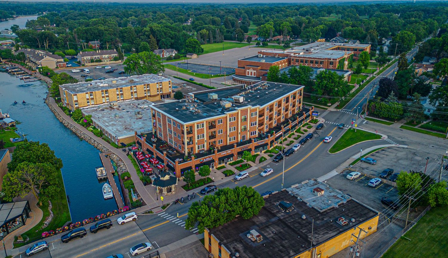 Bird's eye view of downtown buildings and parking lots near a waterfront.