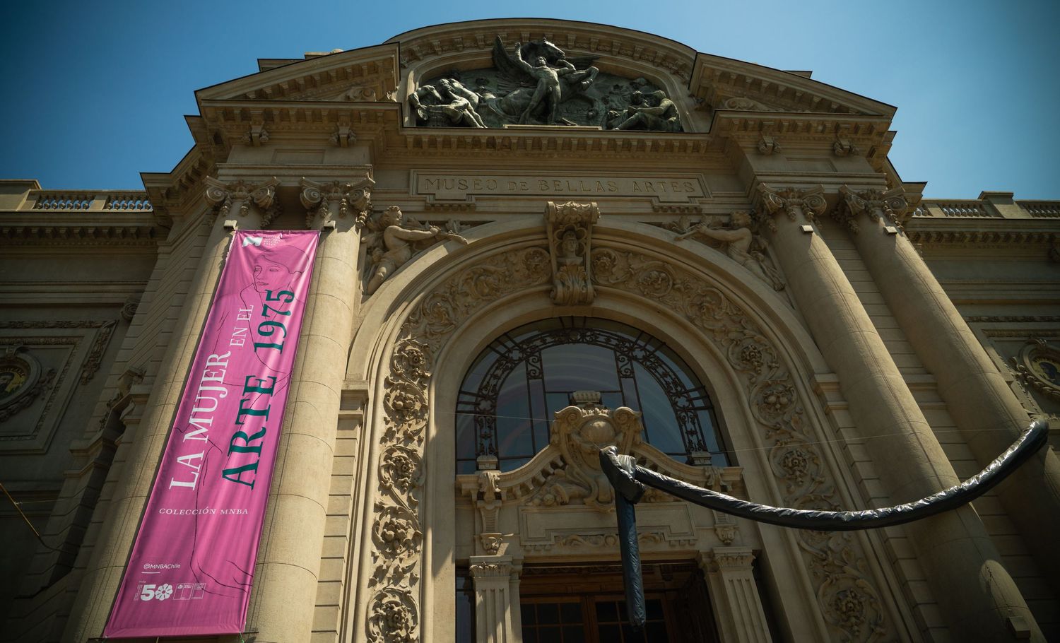 Historic stone building facade with ornate architectural details and pink banner.