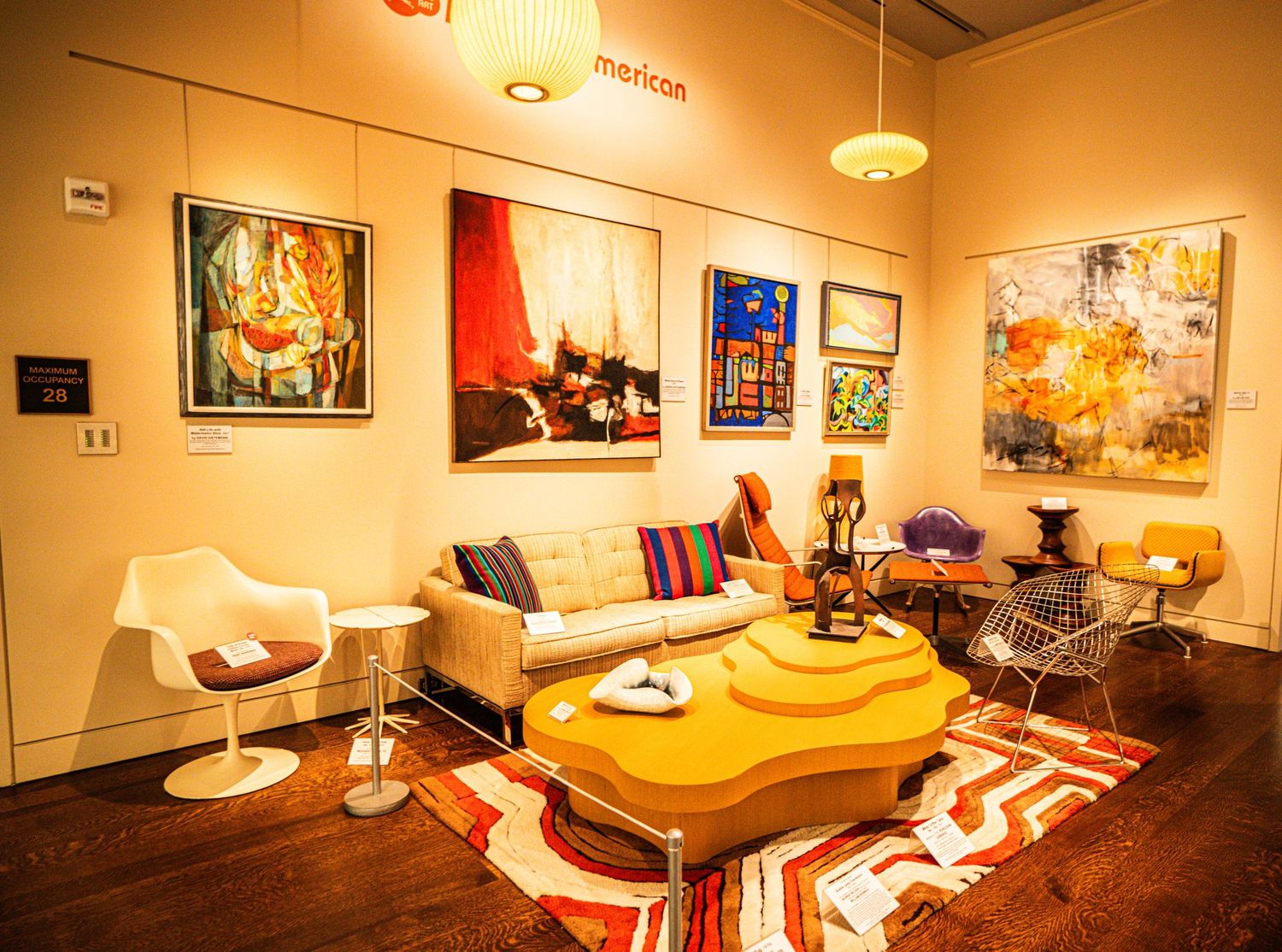 A panoramic view of a cozy lounge area with warm lighting, pool tables, and colorful artwork on the walls.