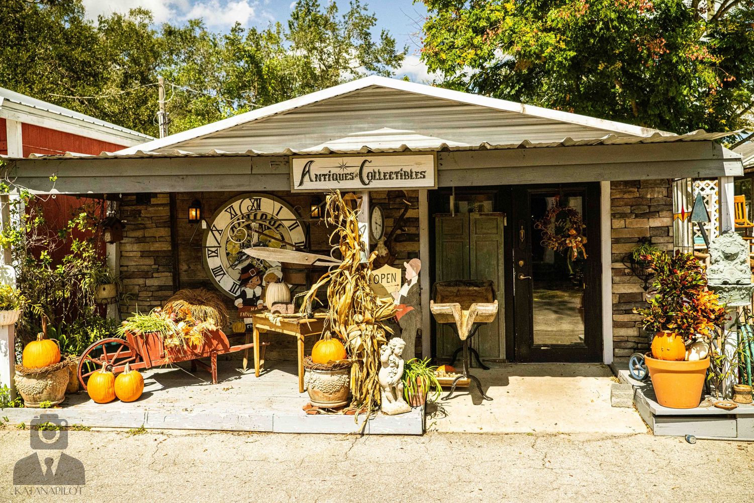 Small country store front decorated with fall pumpkins and harvest decorations.