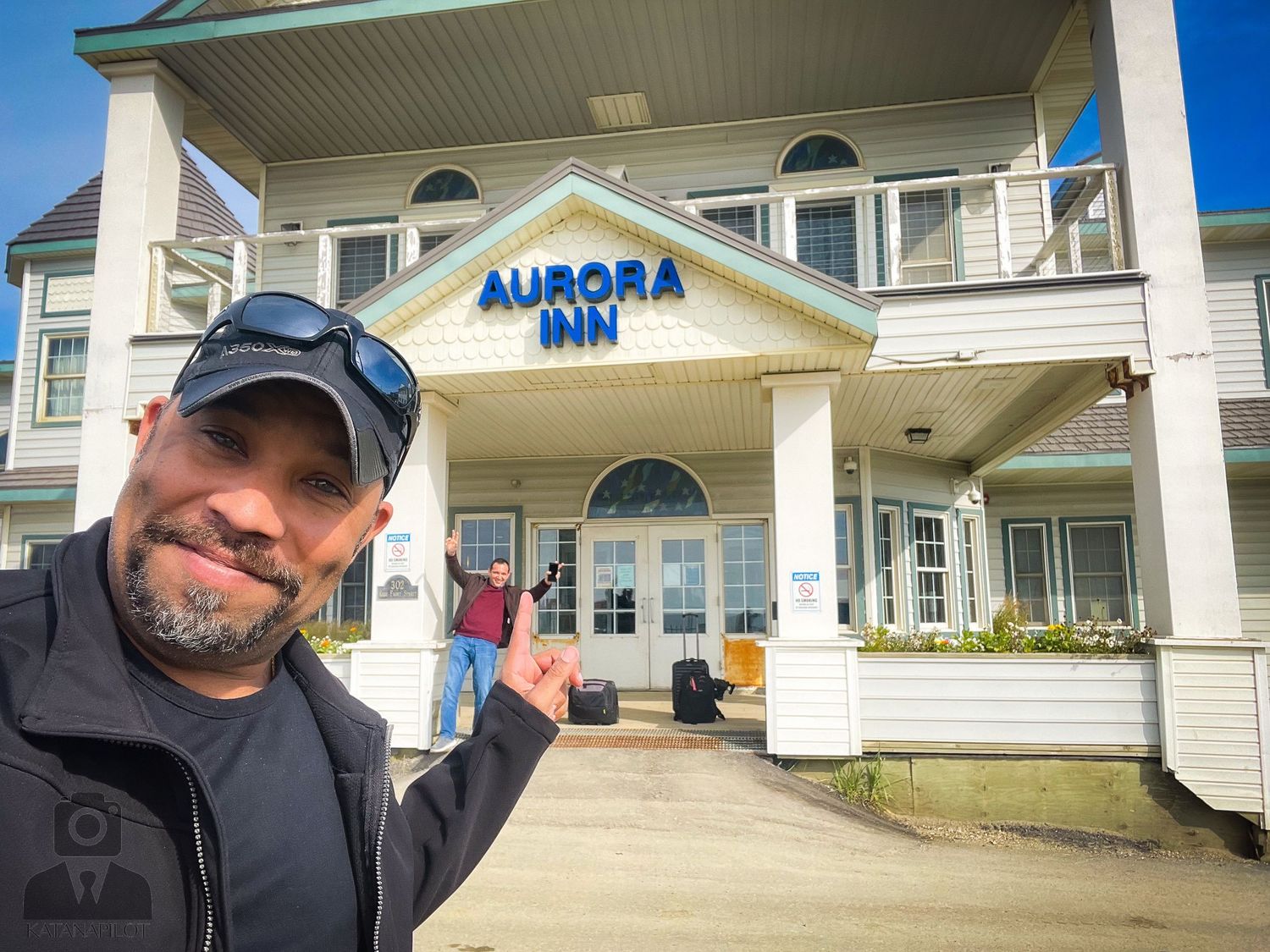 White exterior of the Aurora hotel building with blue signage visible.