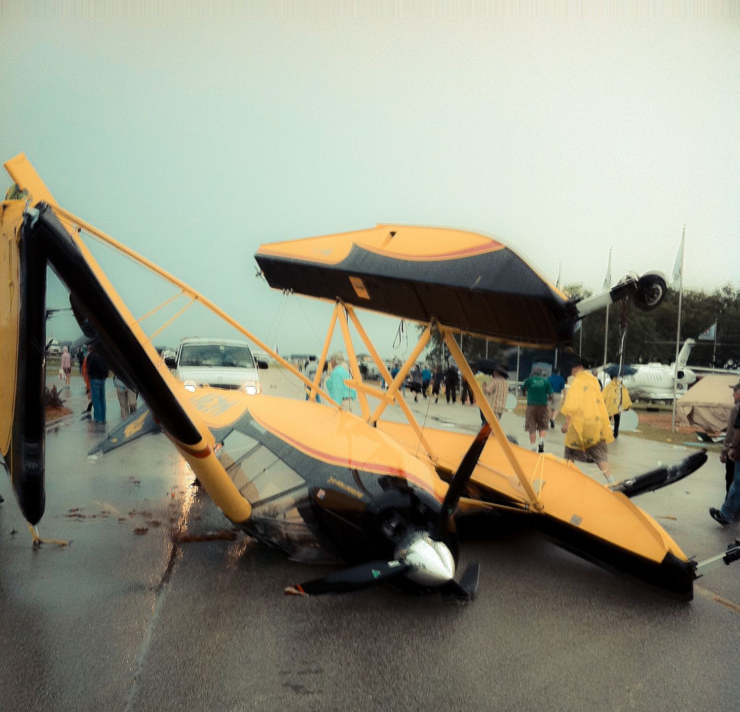 A damaged yellow aircraft lying on its side after an apparent accident or crash, shown in multiple views.