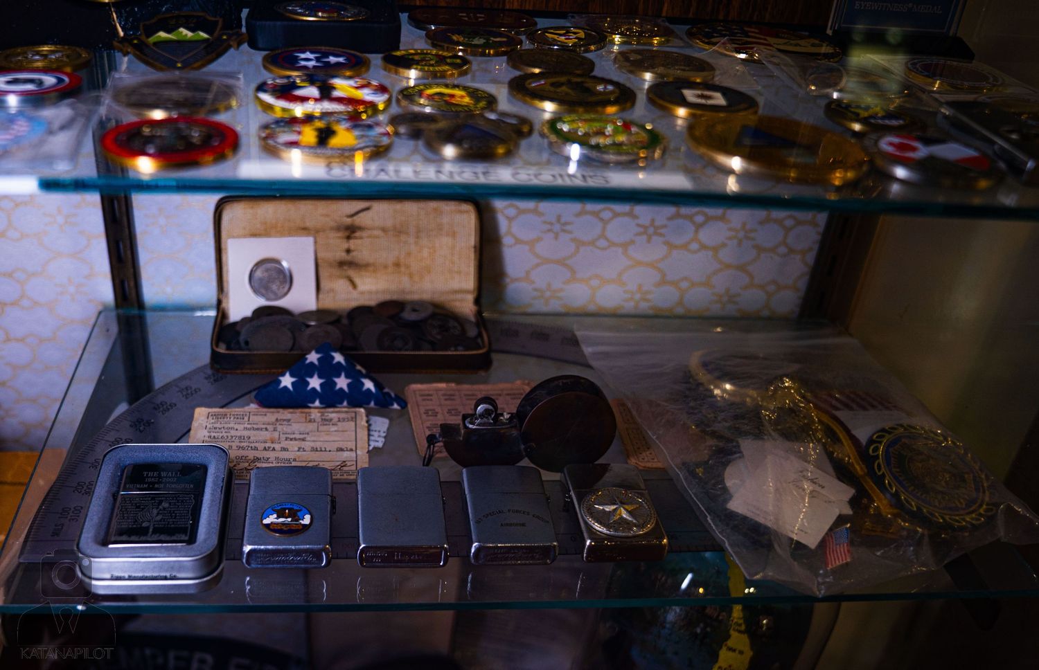 Military medals and decorations displayed in protective cases under lighting.