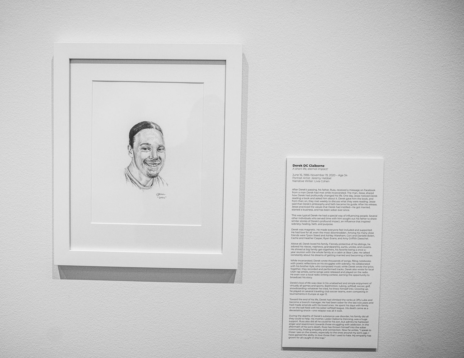 Minimalist gallery installation featuring portrait drawings paired with personal stories on white walls.