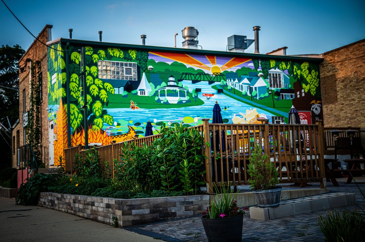 Colorful outdoor mural painted on brick wall depicting a vibrant nature scene.