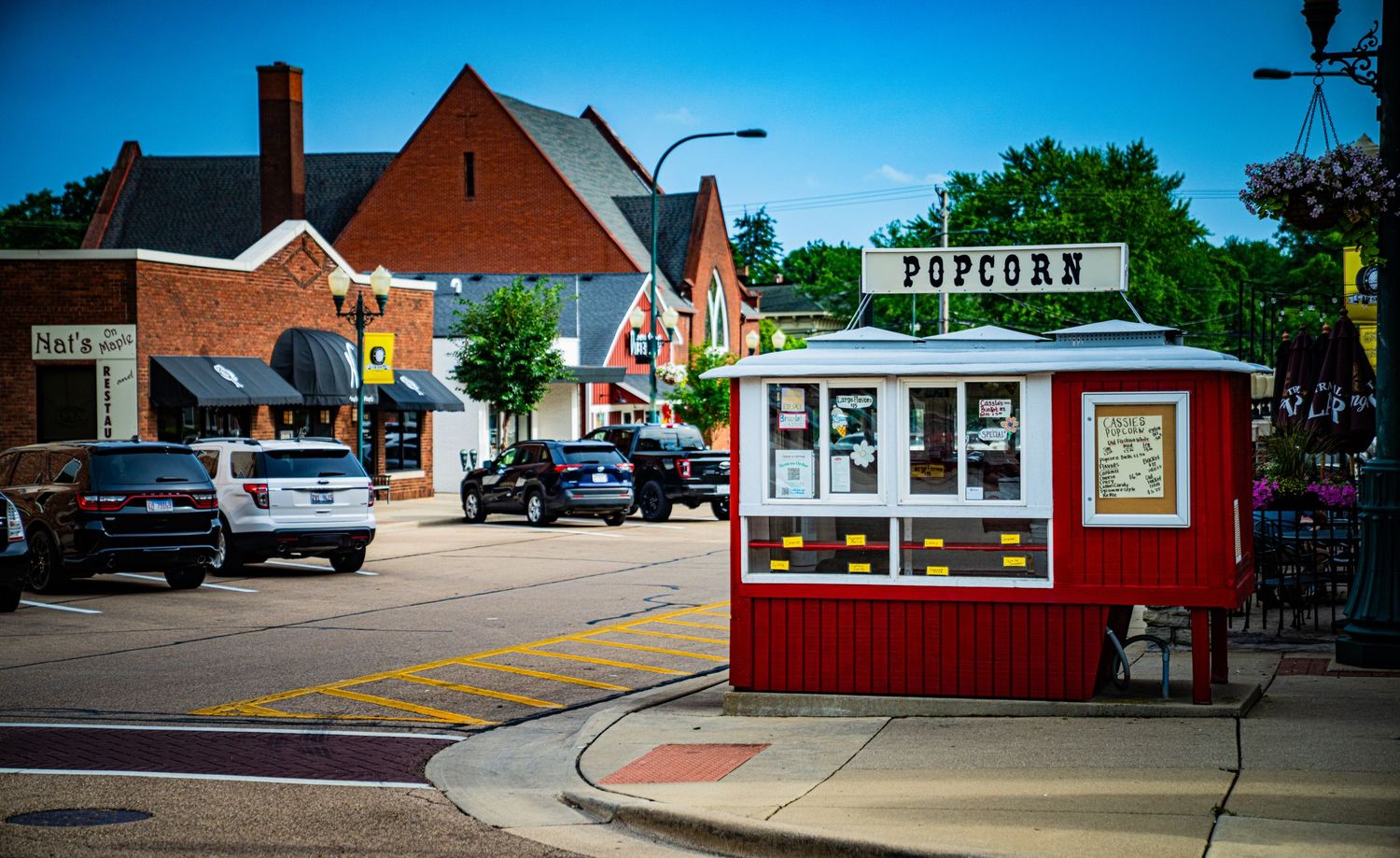 Red vintage storefront buildings with classic architecture along a quiet small town street.