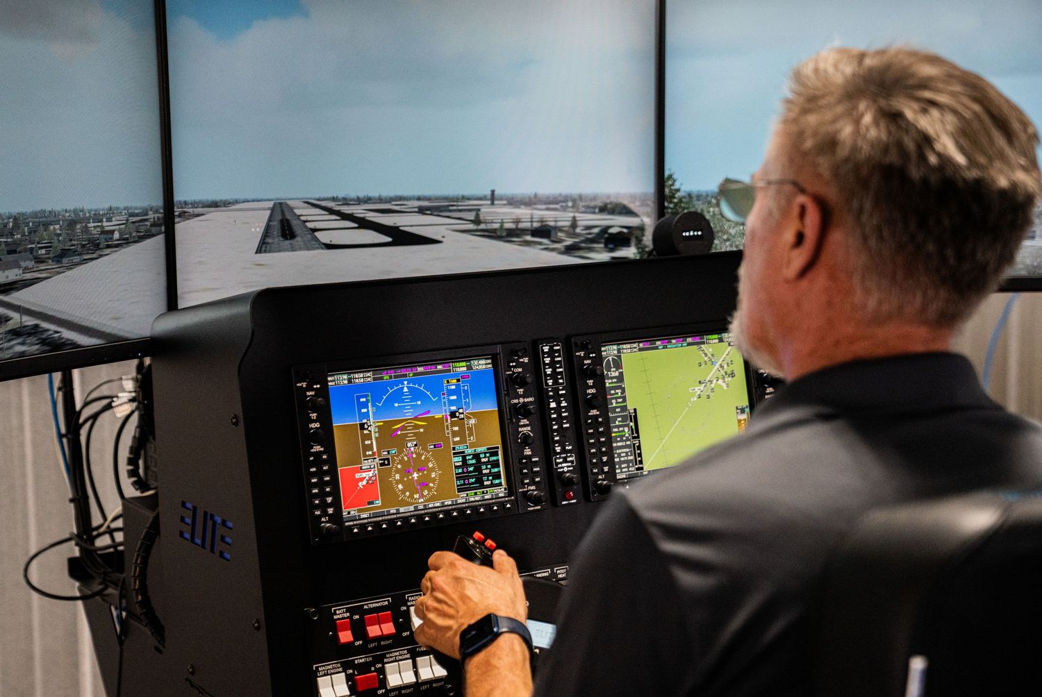 Aviation training room with flight simulator stations and multiple display monitors.