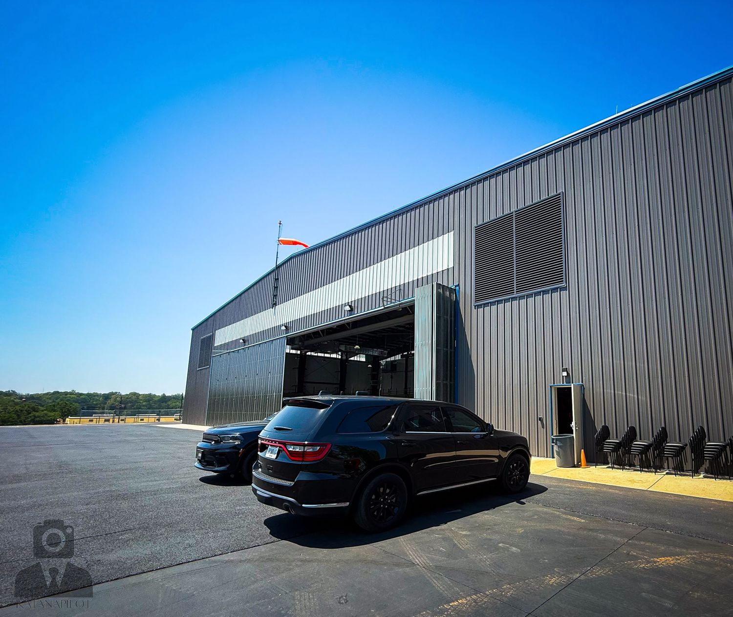 Loading dock area of a commercial warehouse with black vehicles parked outside.