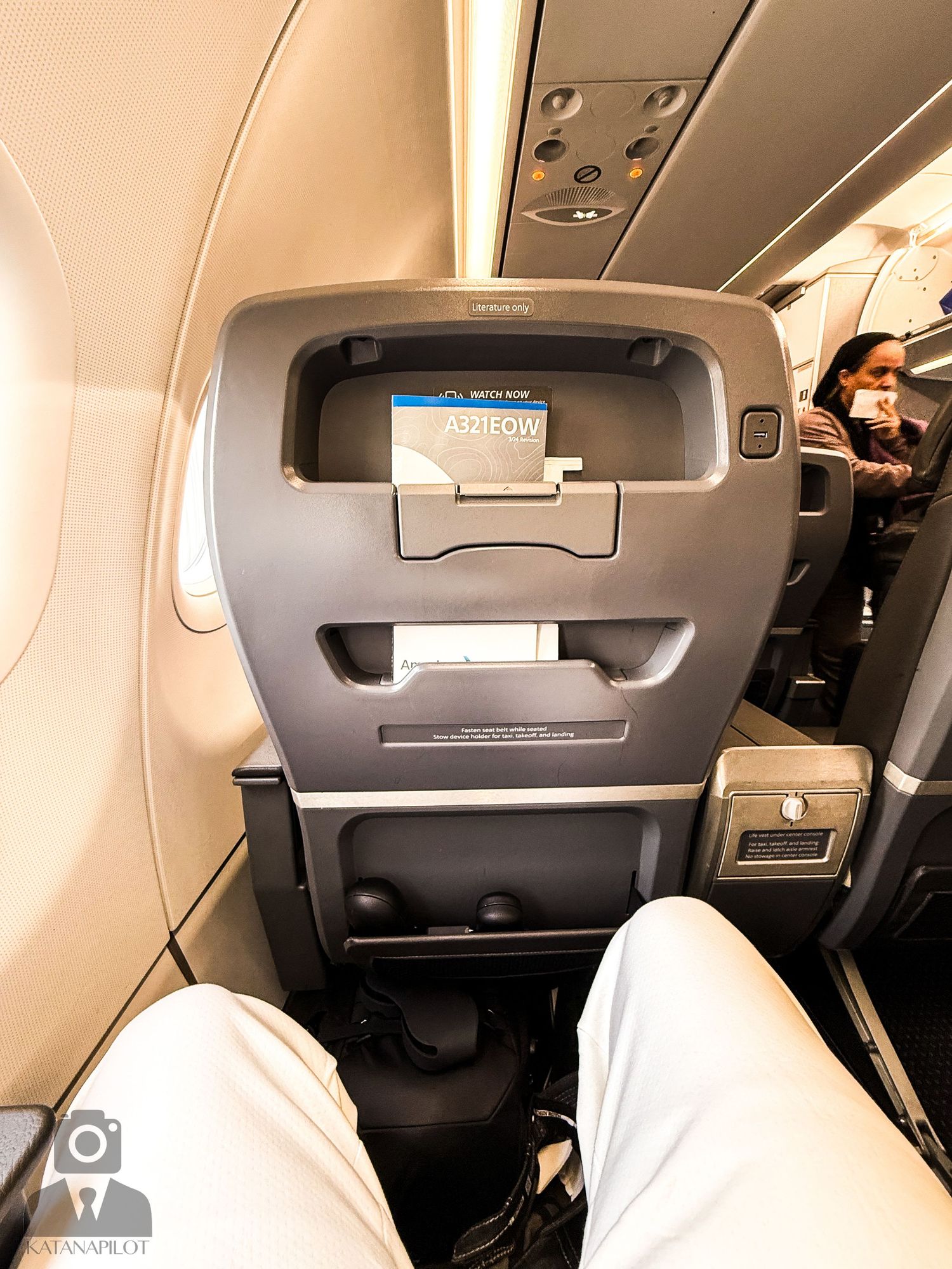 Interior view of modern aircraft cabin with overhead storage compartments.