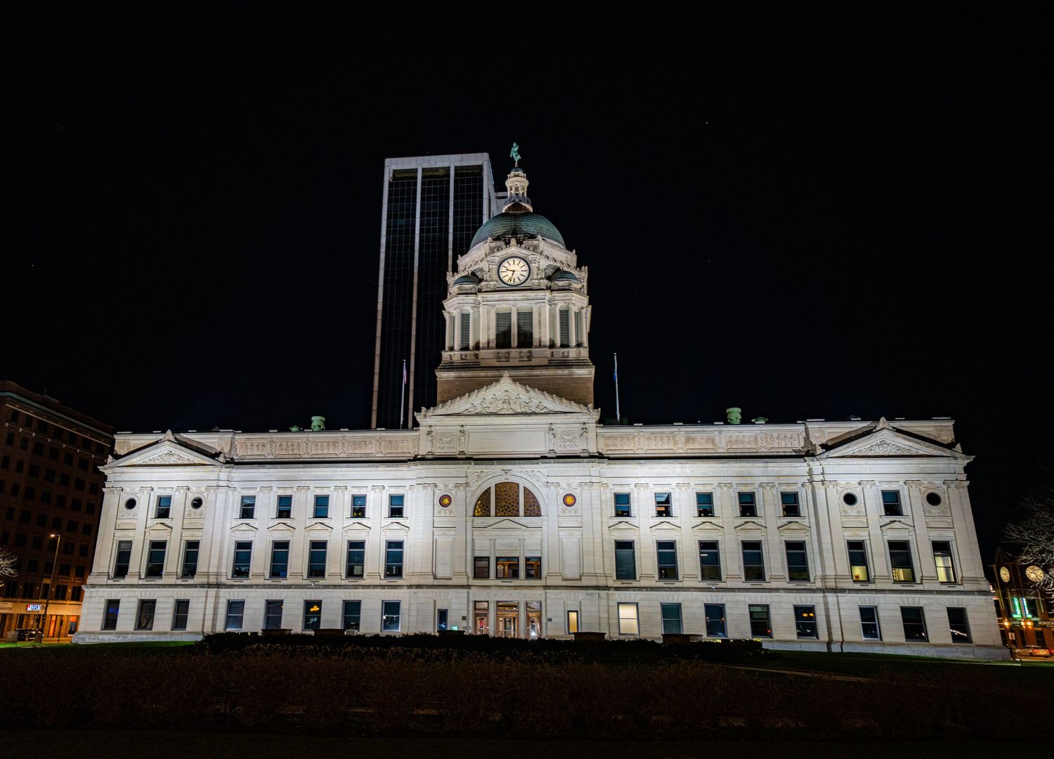 Long white classical building illuminated at night with ornate architectural details.