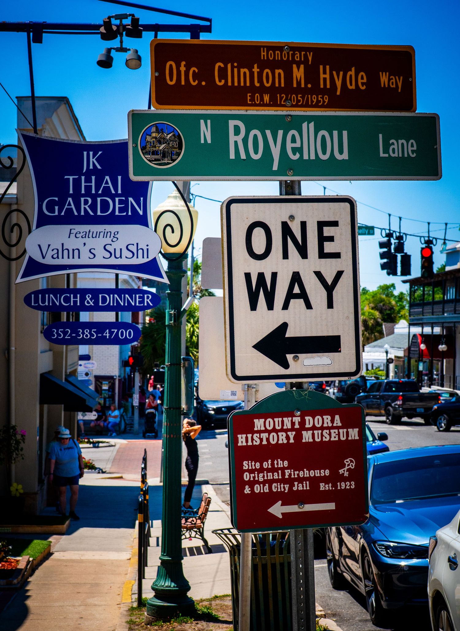Street signs at intersection showing N Royellou Lane and Mount Dora History Museum directions.