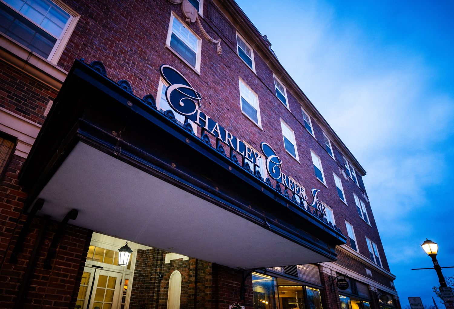 Historic brick building with Charley Creek Inn signage against blue sky.