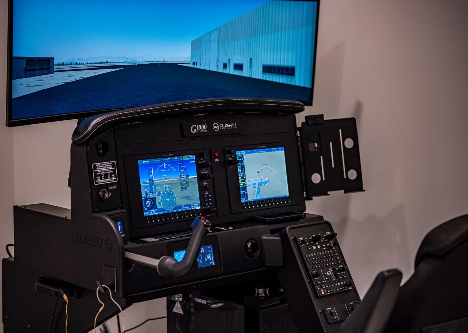 Dark cockpit interior showing digital flight displays and instruments.