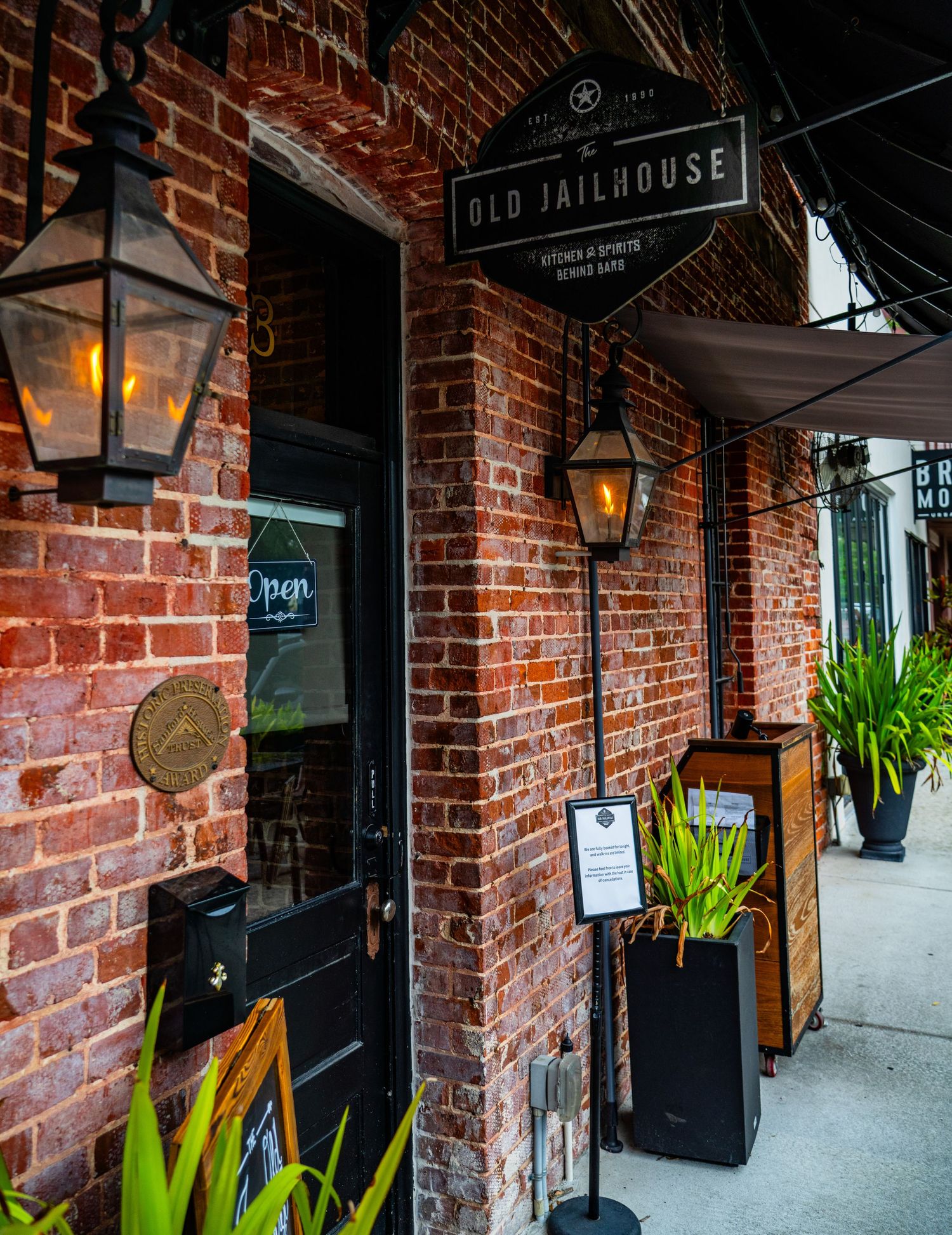 Historic brick building entrance with Old Jailhouse sign and vintage lantern lighting.