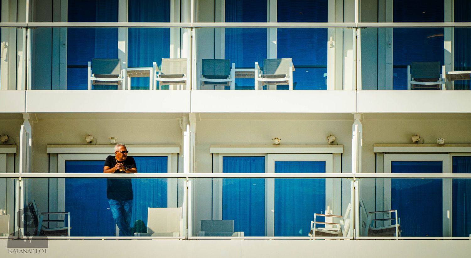 Long horizontal view of contemporary apartment balconies with white and blue architectural details.