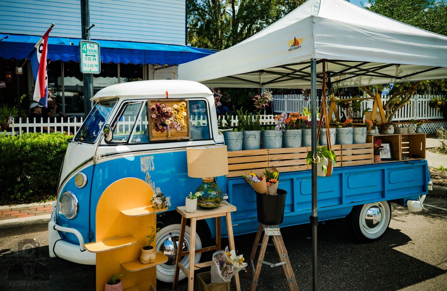 Vintage blue and yellow Volkswagen bus converted into mobile market stall.